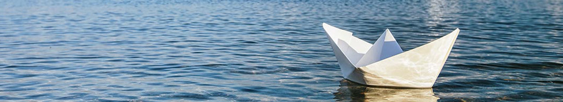 paper boat floating on ocean water 